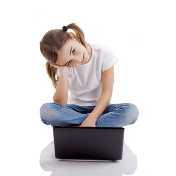 Little girl sitting on floor working with a laptop