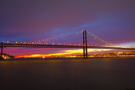 The 25 de Abril Bridge - suspension bridge over the river Tagus illuminated at night. Lisbon Portugal