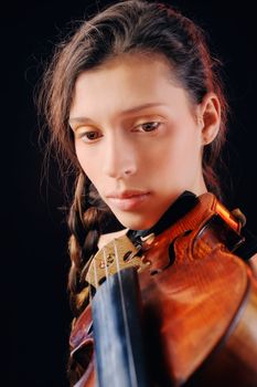 Young woman holding a violin. Isolated on the black background