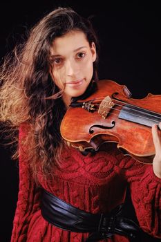 Young woman holding a violin. Isolated on the black background