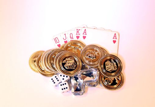 Gold poker chips, diamonds and dice together with a royal straight flush