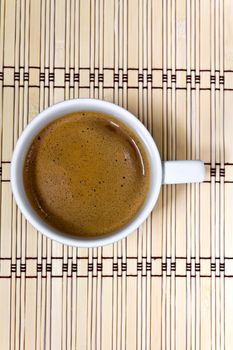 Coffee cup  on a mat made of bamboo