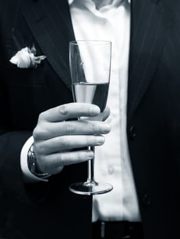Glass of champagne in a hand of the groom