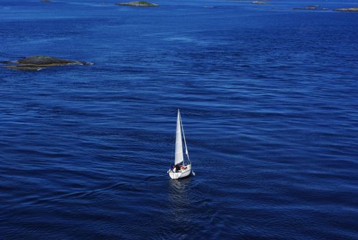 Single sailboat floating on the calm sea