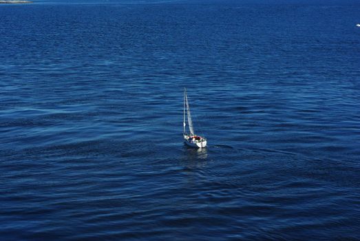 Single sailboat floating on the calm sea