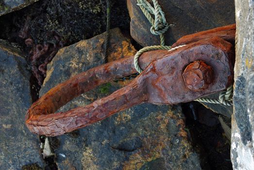 Old rusty iron ring for tying a boat at the pier