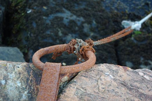 Old rusty iron ring for tying a boat at the pier