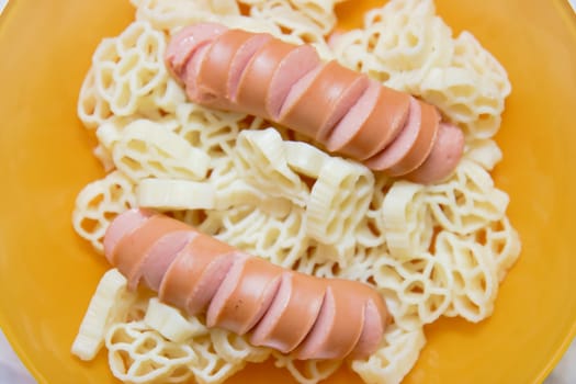 homemade sausage with pasta on the yellow plate
