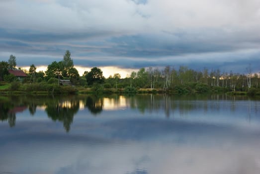 Beautiful lake view with forest coastline in sunset light