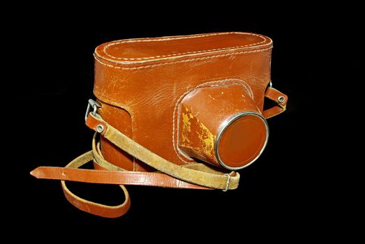 Vintage photo 35mm film camera in brown leather case  on black background