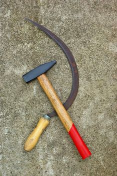 The soviet symbol sickle and hammer on concrete background