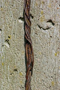 Old rusty rope of iron wires on concret wall background