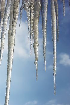 Icicles on the roof against the blue sky