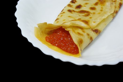 Traditional russian festal day delicacy pancake with caviar isolated on black background