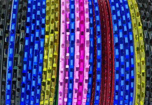 Coloured metallic bracelet rings on white background