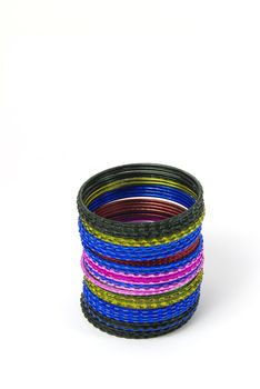 Coloured metallic bracelet rings on white background