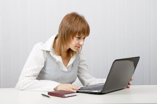attractive young girl with surprise stares at the monitor laptop
