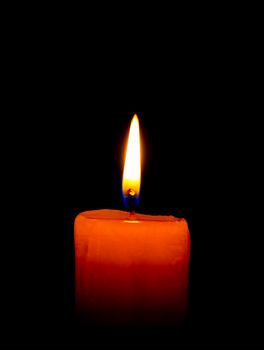 A single burning  candle isolated on  black