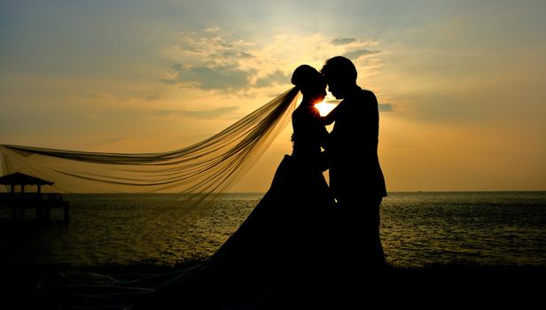 Romantic silhouette of wedding couple  at sunset