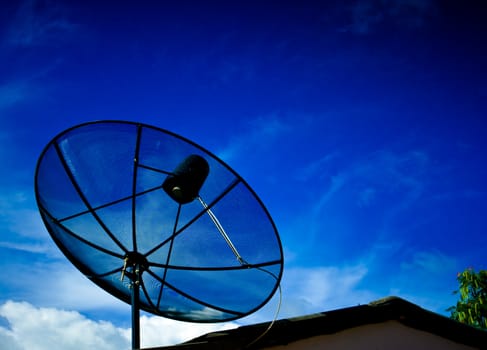 A black satellite dish with blue sky