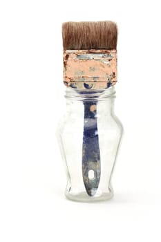 Paintbrush in a glass jar over white