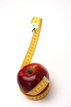 Diet concept.Apple and measure like a snake over white