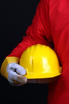 man holding yellow helmet over black background 