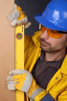 Worker checking vertical level with bubble level tool 