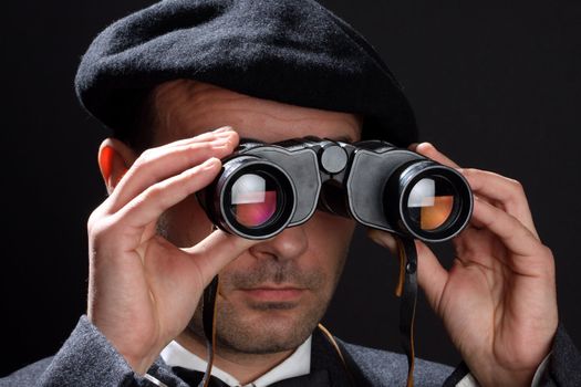 Old fashioned man looking through the binoculars