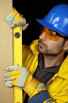 Worker checking vertical level with bubble level tool