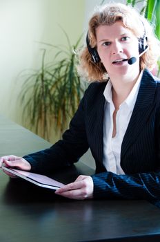 Closeup of a business woman using a tablet pc and talking into headset