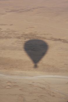 Hot air balloon shadow over the desert Luxor Egypt