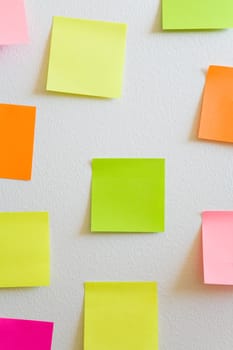 Blank sticky notes attached to a white wall.