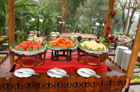 Wooden table with fruit, papaya, watermelon and pineapple