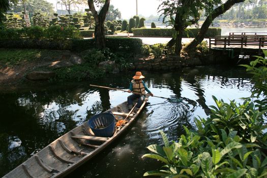 Persons in orange hat in boat cleans lake