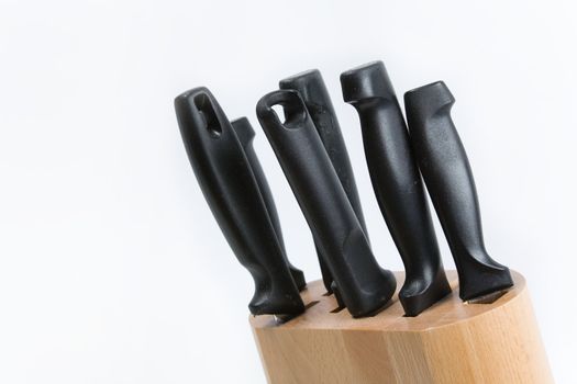 Kitchen knives in a wooden block on a white background