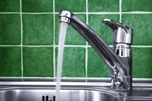 Kitchen water tap and green tiles