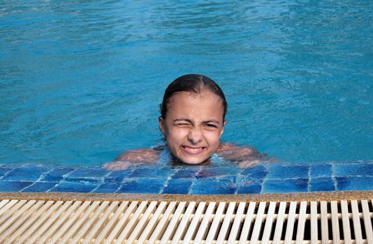 Beautiful girl in pool with blue water