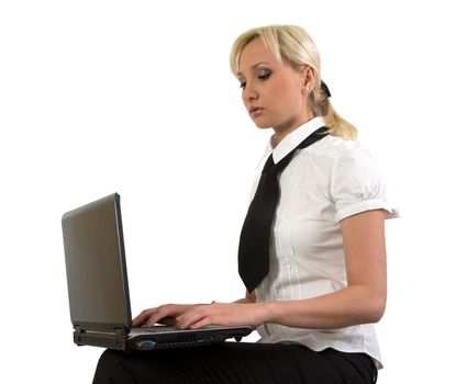 Blond girl working at a laptop isolated on white.