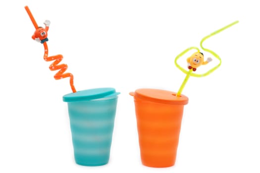 Plastic orange and blue glasses pipe for cocktail on white background