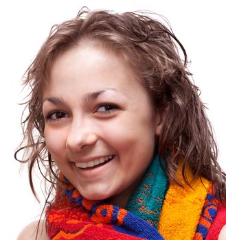 Beautiful girl with wet hair smiles in colour towel, on white background