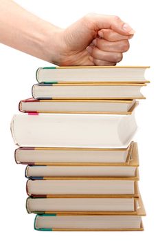Feminine fist on pile of the books insulated on white background