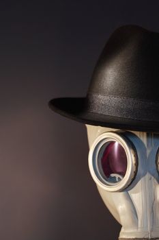 Gas mask with a felt hat closeup on dark background