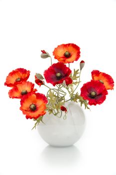 The image of a bouquet of artificial poppies in a vase, isolated, on a white background.