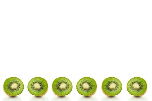 Six small kiwi fruit halves arranged in a horizontal line along the bottom of the image and over white.