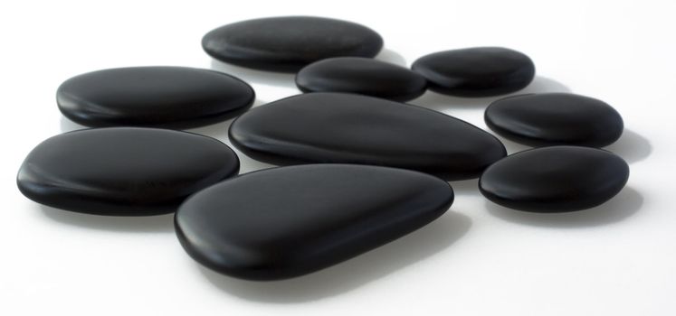 Black basaltic stones for massage over gray background