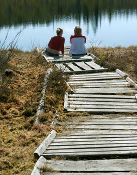 Two girls sit on pier north lake