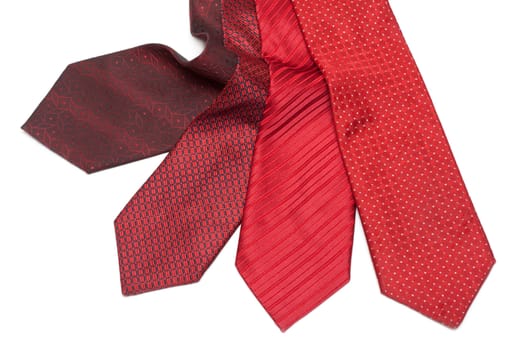 Four male ties, red and crimson on white background
