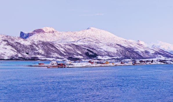 Panorama. Polar night in Norway. Mountains, fjords, and the moon, typical Norwegian house