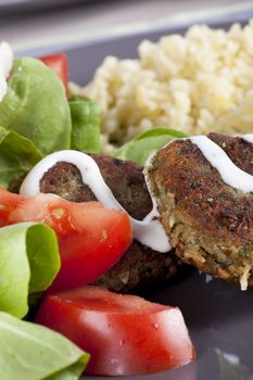 Falafel with yogurt sauce with tomatoes, lettuce and bulgar.